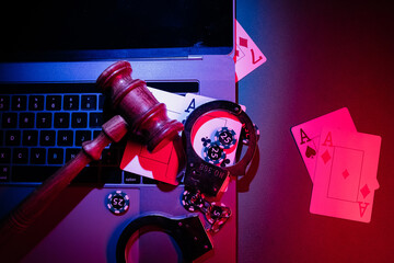 Chips, cards and wooden gavel on the laptop. Online casino and gambling concept