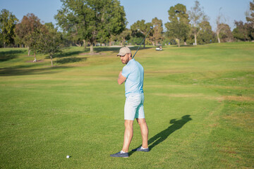 golfer in cap with golf club. people lifestyle. man playing game on green grass. summer activity