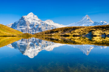 Obraz premium High mountains and reflection on the surface of the lake. Mountain valley with lake. Landscape in the highlands in the summertime. Photo in high resolution.