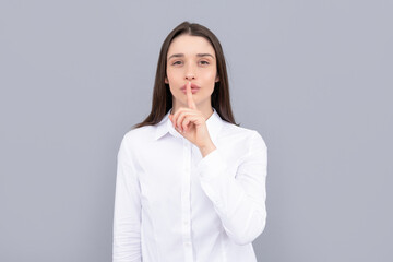 hush gesture of businesswoman in white shirt on grey background, entrepreneur