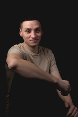 Handsome guy posing in studio on isolated black background. Studio portrait with one light source.