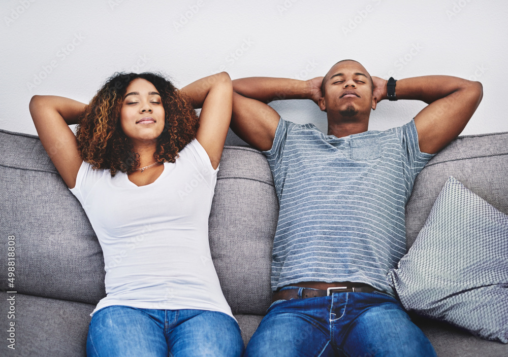 Poster Take time to take a timeout. Shot of a young couple resting on a couch at home.