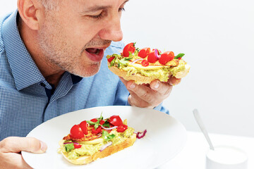 Healthy open vegan sandwich with avocado mash, zucchini, cherry tomatoes, cheese on top of corn bread. Healthy food, vegetarian food concept