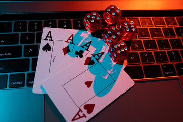 Casino theme. Red dices and cards are on laptop. Poker online