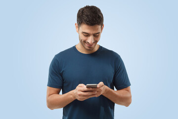 Happy attractive European man looking attentively at screen of cellphone, browsing web