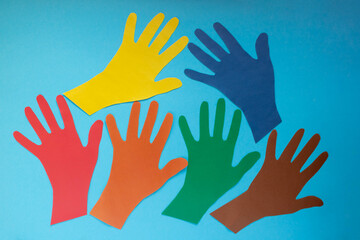 Abstract background open multicolored paper palms on a blue background.The concept of Autism Day and Youth Solidarity Day