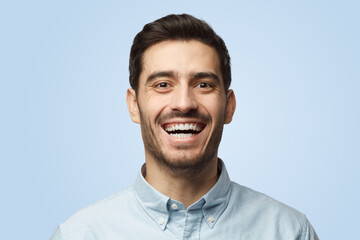 Joyful bearded attractive business man smiles broadly, shows white perfect teeth
