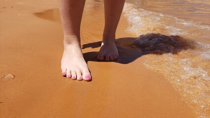 Bare feet with a pedicure on a beach vacation