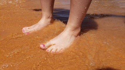 Fototapeta premium Bare feet with a pedicure on a beach vacation