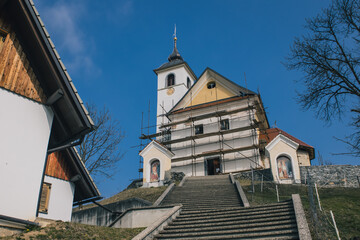 Fototapeta na wymiar Frog view of Saint Mohor and Fortunat church on the top of the hill in central Slovenia close to Lukovica.