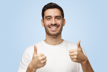 Motivated excited attractive young man makes thumbs up gesture of approval