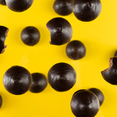 esthetic photo of cookies in chocolate of round shape with a nut on a yellow background, top view