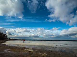 panoramic view of spring river with man on ice