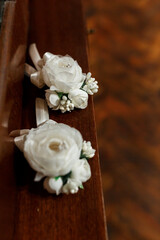 Groom's boutonniere with white flowers on brown background