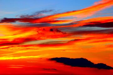 Breathtaking sunset of red, orange and yellow colours on the blue sky with weird clouds in Monte Vidon Corrado