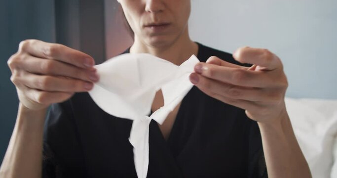 Woman unpack sheet face mask for doing a skincare beauty routine with product application