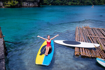 Summer holidays vacation travel. Young woman ralaxing on paddle board in beautiful calm lagoon. Siargao Island, Philippines.