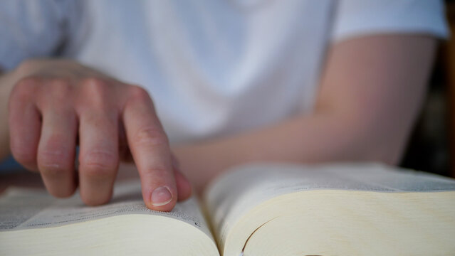 Woman reading the bible, pointing finger on text