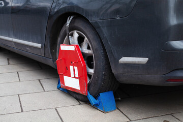 Car wheel clamp Locked illegally parked cars Car wheel blocked by wheel lock because of illegal...