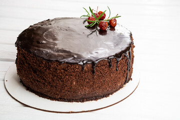 Large chocolate cake with cherries on top on a white background