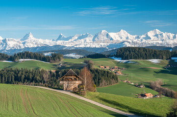 traditional Bernese farmhouse called Stöckli in front of the mighty Bernese Alps in spring