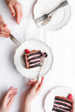 Raspberry and chocolate cake slices, on plates with forks.