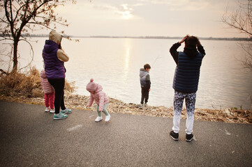 Fototapeta premium Mother with kids on the shore of the lake.