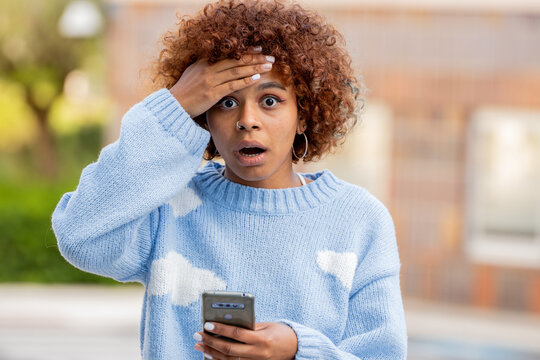 surprised or amazed girl with mobile phone