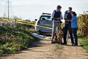 An unfortunate end. Shot of two policemen interviewing a woman at a crimescene.