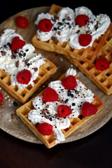 Soft focus. Macro. French waffles with cream and fresh raspberries.