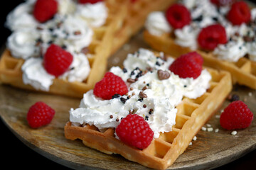Soft focus. Macro. French waffles with cream and fresh raspberries.