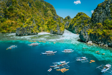 Aerial view of tourist boats in front of big Lagoon at Miniloc Island, El Nido, Palawan,...