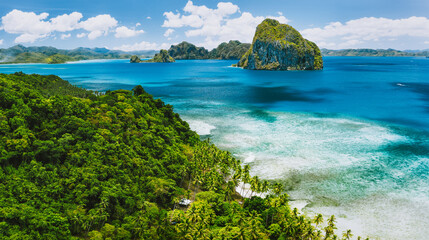 El Nido, Palawan, Philippines. Panoramic aerial view of exotic tropical Pinagbuyutan island, blue sea, lagoon and palm trees. Southeast Asia Bacuit archipelago