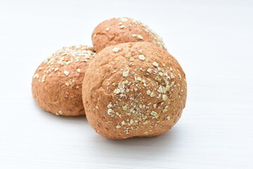 Round wholemeal oat bread, sweetened with natural panela, displayed on white wood