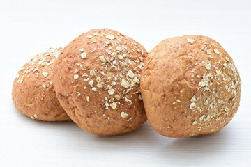 Round wholemeal oat bread, sweetened with natural panela, displayed on white wood