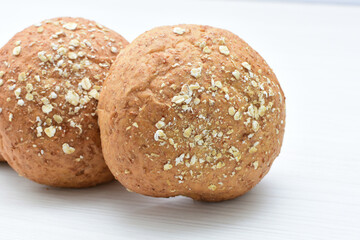 Round wholemeal oat bread, sweetened with natural panela, displayed on white wood