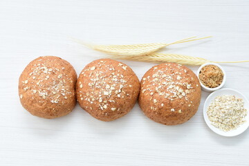 Round wholemeal oat bread, sweetened with natural panela, displayed on white wood