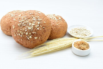 Round wholemeal oat bread, sweetened with natural panela, displayed on white wood