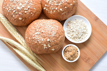 Round wholemeal oat bread, sweetened with natural panela, displayed on white wood