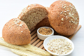 Round wholemeal oat bread, sweetened with natural panela, displayed on white wood
