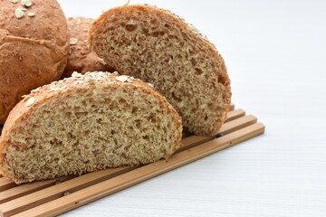Round wholemeal oat bread, sweetened with natural panela, displayed on white wood