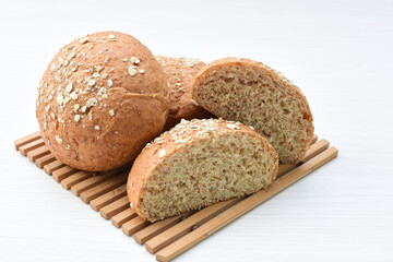 Round wholemeal oat bread, sweetened with natural panela, displayed on white wood