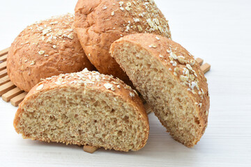 Round wholemeal oat bread, sweetened with natural panela, displayed on white wood