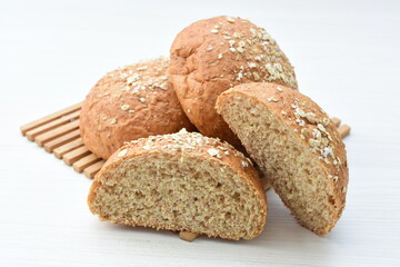 Round wholemeal oat bread, sweetened with natural panela, displayed on white wood