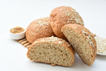 Round wholemeal oat bread, sweetened with natural panela, displayed on white wood