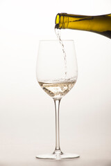 white wine is poured into a special glass on a light background in the studio close-up without a person