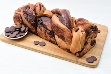 Large chocolate artisan bread, extra chocolate displayed on white wood