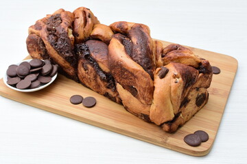 Large chocolate artisan bread, extra chocolate displayed on white wood