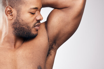 Whats that smelly smell. Studio shot of a handsome young man smelling his armpit against a white...