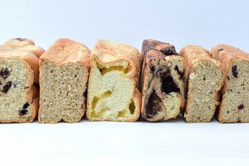 Mix of artisan breads of different natural flavors, displayed on a wooden background